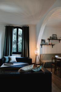 Una sala de estar con un sofá y una ventana. en Villa les Grillons, en Hyères