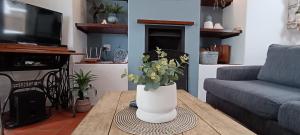a living room with a vase with flowers on a table at River View Cottage - at the Breede in Witsand