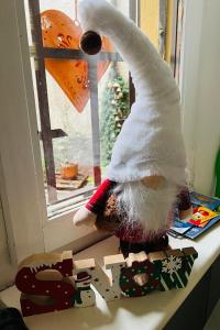 a stuffed teddy bear is standing on a window sill at Casa Emma in Porto Ceresio