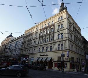 duży budynek na ulicy z samochodami zaparkowanymi przed w obiekcie Carpe Diem Prague w Pradze