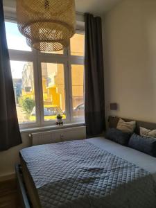 a bedroom with a bed and a large window at City Villé Ferienwohnung Innenstadt in Neubrandenburg
