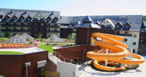 a large water slide in front of a building at VacationClub - Sarnia Residence Apartament 35 in Karpacz