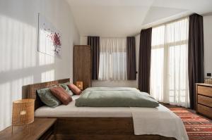 a bedroom with a large bed in a room with windows at Вила Франк/Villa Frank in Enina +35 photos
