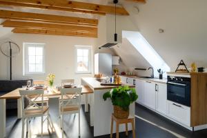 a kitchen with white cabinets and a table and chairs at Hiša Janko in Dolenjske Toplice