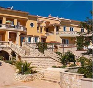 a large house with stairs in front of it at Una Sole in Nerezine