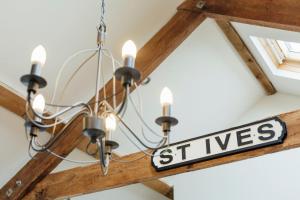 a chandelier with a street sign hanging from a ceiling at Lower Trowan Cottage in Sharnbrook +17 photos
