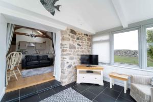 a living room with a stone wall at Lower Trowan Cottage in Sharnbrook