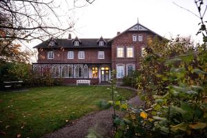 a large brick house with a lawn in front of it at Ferienwohnung Groote Stuuv - Stein in Stein