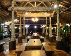 a large room with wooden tables and a chandelier at Warung Rekreasi Bedugul in Bedugul