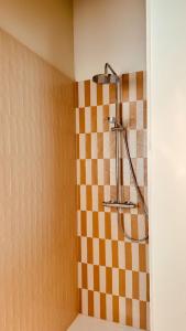 a shower in a bathroom with a checkered wall at Staf Vakantiewoning De Haan centrum in De Haan +29 photos