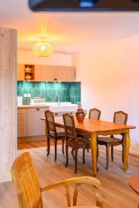 a kitchen with a wooden dining table and chairs at Les Iris Blancs in Orbey