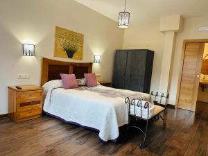 a bedroom with a large bed and a wooden floor at Casa Rural Cristina in Morcuera