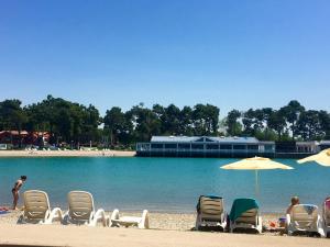 Un grupo de sillas y sombrillas en una playa. en Apartment Anchy, en Umag