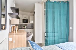 a bedroom with a blue shower curtain and a kitchen at STUDIOS cosy Quartier Harteloire proche centre-ville in Brest +41 photos