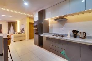 a kitchen with a stove top oven next to a living room at Spacious 2 Bedroom Flat in Lekki Phase 1 in Lekki