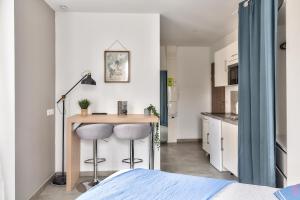 a bedroom with a desk and two stools at STUDIOS cosy Quartier Harteloire proche centre-ville in Brest