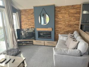 a living room with a couch and a tv at 7A Dolphin Point in Ashington