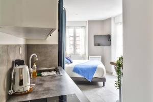 a room with a bed and a kitchen with a sink at STUDIOS cosy Quartier Harteloire proche centre-ville in Brest