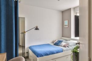 a small bedroom with a bed with blue sheets at STUDIOS cosy Quartier Harteloire proche centre-ville in Brest