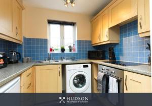 a kitchen with a washing machine and a sink at Telford 2-Bedroom Apartment in Telford