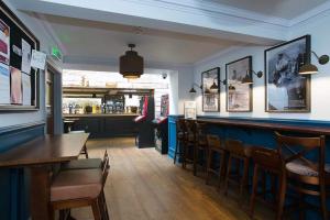 um bar com mesas e cadeiras de madeira num restaurante em The Cross Keys Wetherspoon em Peebles