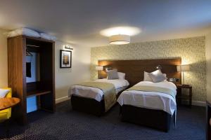 um quarto de hotel com duas camas e uma televisão em The Cross Keys Wetherspoon em Peebles
