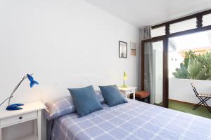 una camera da letto con un letto con cuscini blu di Home2Book Ocean Park Cozy Apt with Pool, Adeje ad Adeje Altre 32 foto