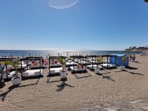 una spiaggia con un mucchio di letti sulla sabbia di Home2Book Ocean Park Cozy Apt with Pool, Adeje ad Adeje