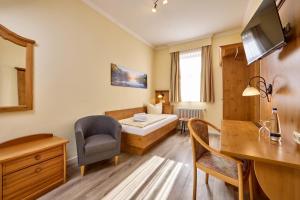 a room with a bed and a desk and a chair at Hotel Vier Jahreszeiten in Garmisch-Partenkirchen
