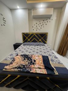 a bedroom with a bed with a quilt on it at Mehar Heights in Rāmkot