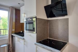 a kitchen with a stove and a microwave at Suite du lac, Centre-ville, Lac & Casino à 2 min in Enghien-les-Bains