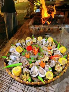 a plate of seafood and vegetables on a grill at Waikiki Lagi Beach homestay & restaurant in La Gi