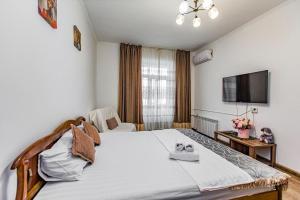 a bedroom with a large bed and a tv at Двухкомнатная евро двушка в самом центре Алматы, 10 минут ходьбы до Арбата #32 in Almaty