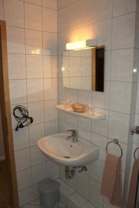 ein Bad mit einem Waschbecken und einem Spiegel in der Unterkunft Zum Landkrog in Barmstedt