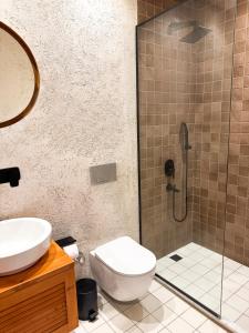 a bathroom with a shower and a toilet and a sink at Churchill Townhouse in Bodrum City