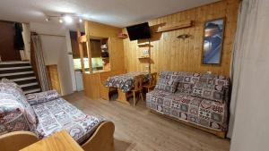 a living room with a couch and a table at Les Menuires Résidence Brelin Skis aux pieds in Les Menuires