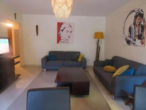 un soggiorno con un divano blu e un tavolo di Appartement spacieux à Montpellier de 95 m² a Montpellier