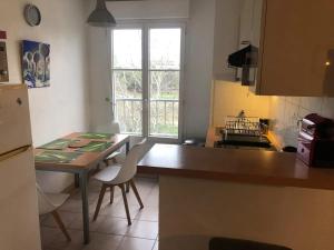 una cucina con tavolo, sedie e piano di lavoro di Appartement moderne à Montpellier, 45 m², climatisation a Montpellier