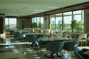 a dining room with tables and chairs and windows at La Zona Continental Hotel in Dubai