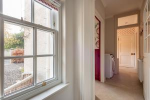 a hallway with a window in a house at The Windmill Room - 1 min to Old Course in St. Andrews +23 photos