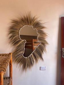 un espejo en una pared con una gran pluma yigunigunigunigunigunigun en Paje Village House, en Paje