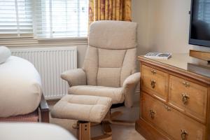 a bedroom with a chair and a desk and a television at The Windmill Room - 1 min to Old Course in St. Andrews