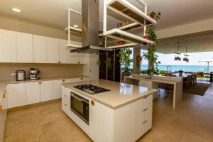 une cuisine avec des armoires blanches et une vue sur l'océan dans l'établissement Espectacular Villa en Pocitas, à Puerto Máncora