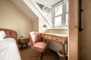 a bedroom with a desk with a chair and a window at Meldon View - Period Apartment & Roof Terrace in Chagford