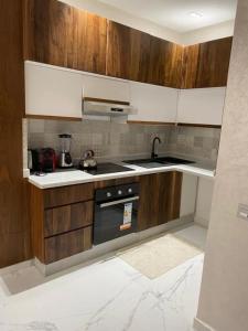 a kitchen with wooden cabinets and a stove top oven at KH APPARTEMENT appart1 in Essaouira