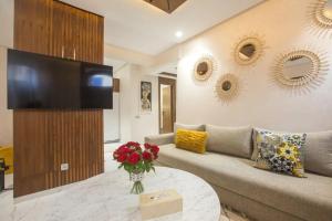 a living room with a couch and a table with flowers at KH APPARTEMENT appart1 in Essaouira