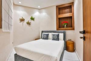 a small bedroom with a white bed and a window at KH APPARTEMENT appart1 in Essaouira