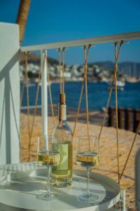 two wine glasses on a table with a bottle of wine at Churchill Townhouse in Bodrum City