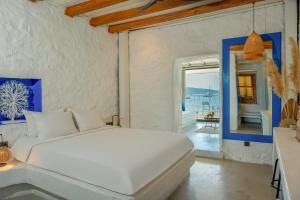 a white bedroom with a bed and a balcony at Churchill Townhouse in Bodrum City