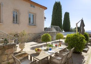 une table et des chaises en bois devant une maison dans l'établissement Villa La Pax, à Mougins